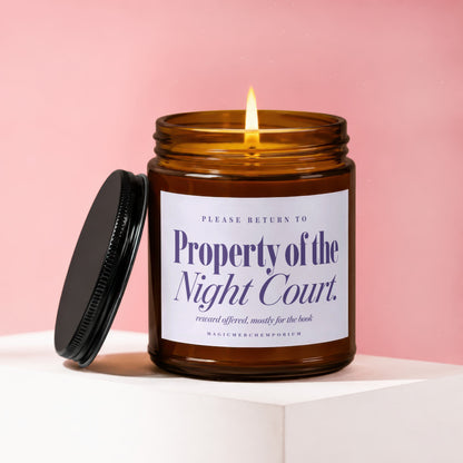 Amber glass candle with lit wick, lid beside it, reads Property of the Night Court.