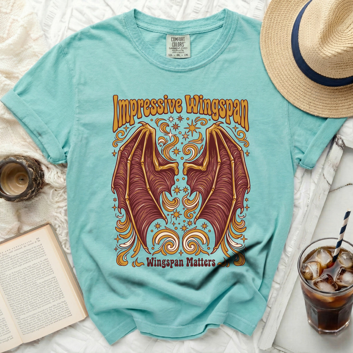 Teal t-shirt with golden brown wings and "Impressive Wingspan Wingspan Matters" text.