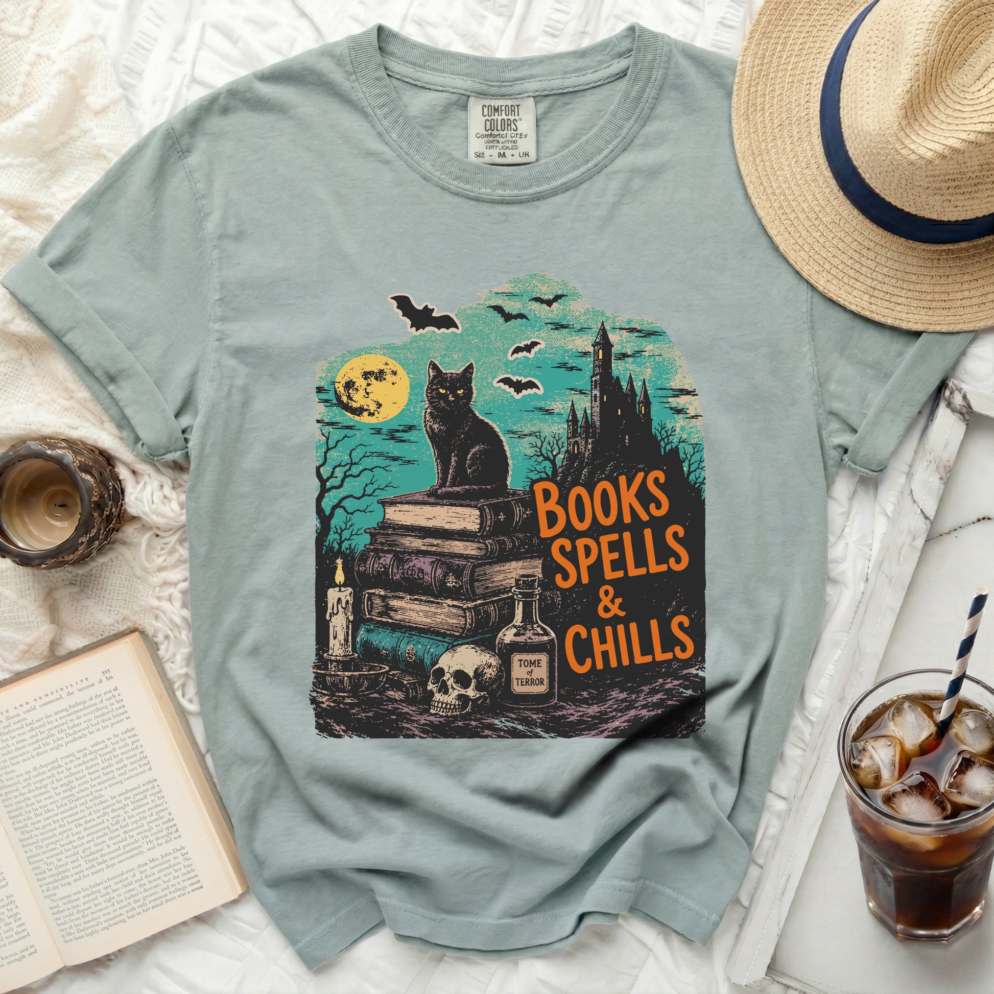 Black cat on books in front of spooky castle, "Books Spells & Chills" text.
