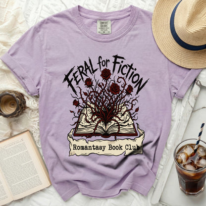 Purple t-shirt with "Feral for Fiction" and "Romantasy Book Club" text and graphics.