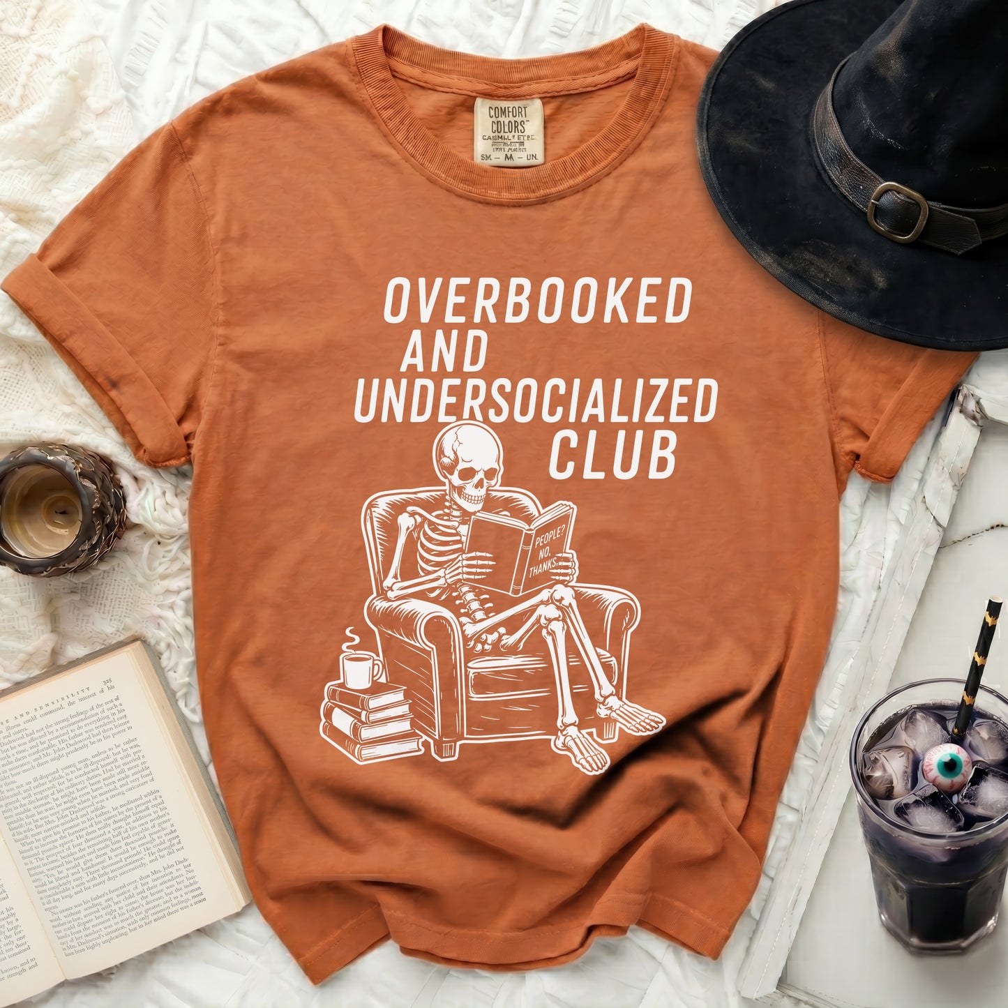 Orange t-shirt with "Overbooked and Undersocialized Club" and skeleton.