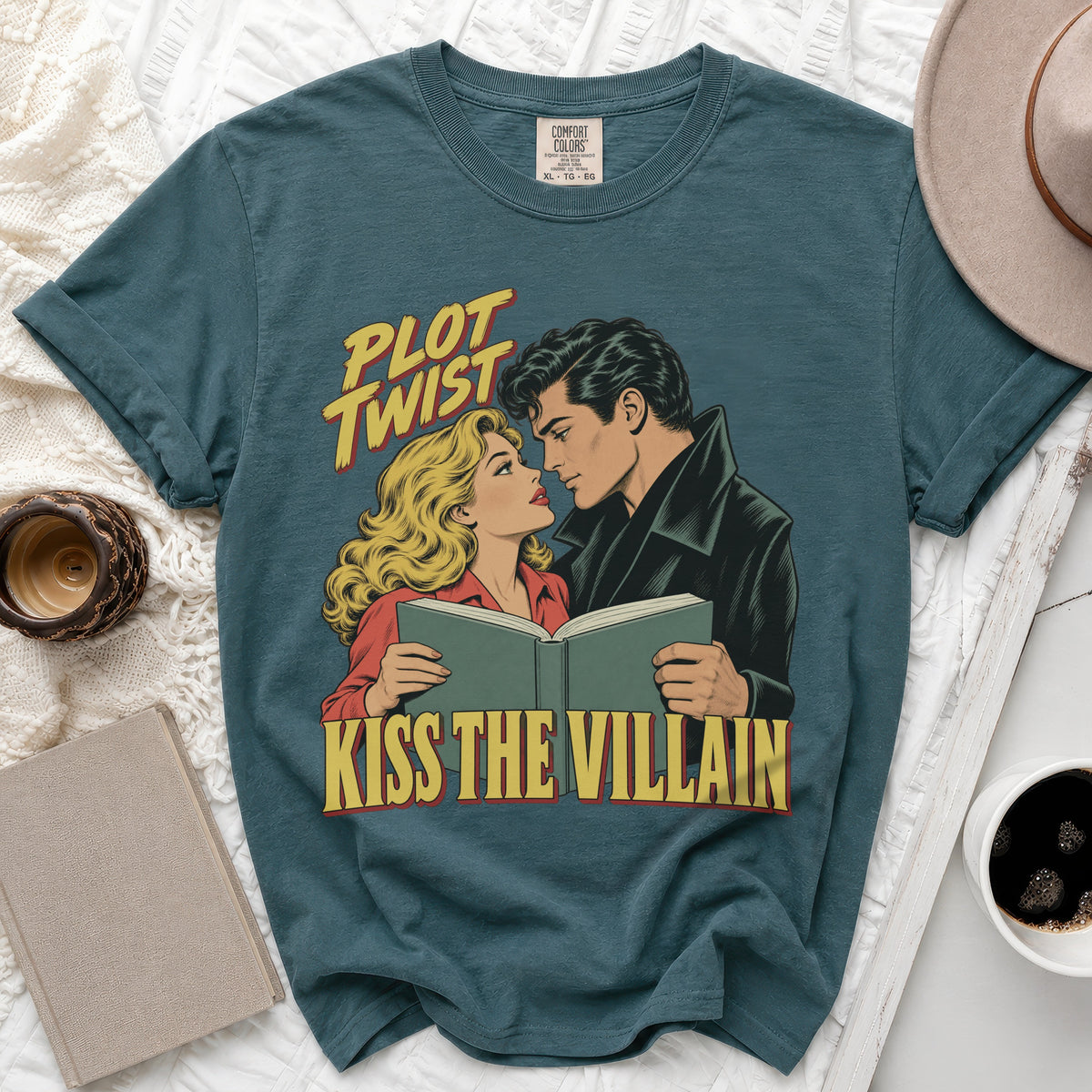 Teal t-shirt with comic book art of a couple reading and text "Plot Twist Kiss the Villain."