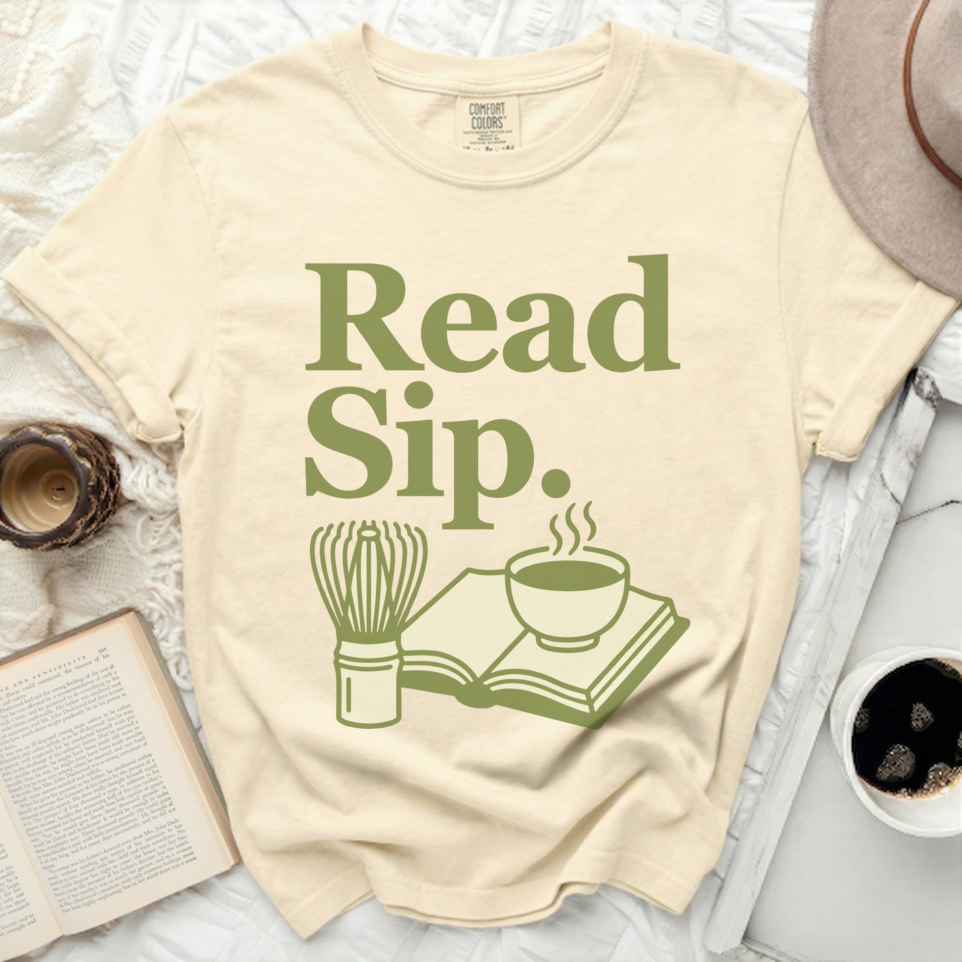 Cream t-shirt with "Read Sip." in green, featuring book and beverage icons.