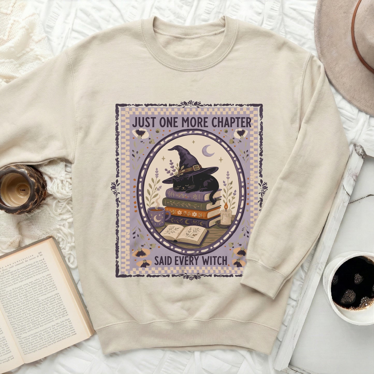 Cream sweatshirt with "Just One More Chapter Said Every Witch" graphic.