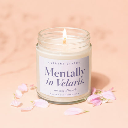 Candle with "Mentally in Velaris" text, lit and surrounded by pink petals.