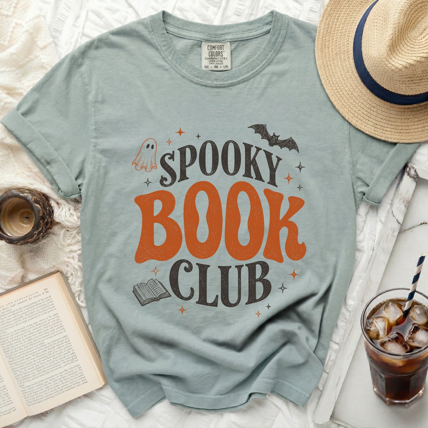 Light blue t-shirt with "Spooky Book Club" text, ghost, bat and book graphics.