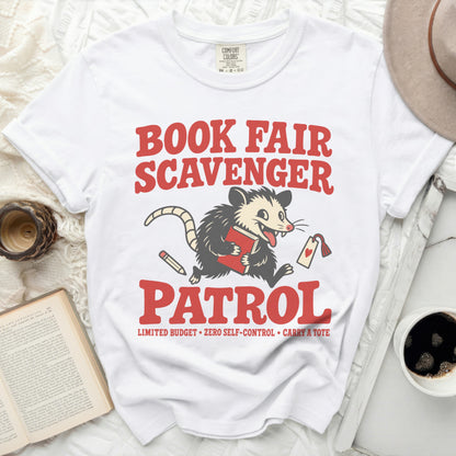 White t-shirt with "Book Fair Scavenger Patrol" graphic and a possum.