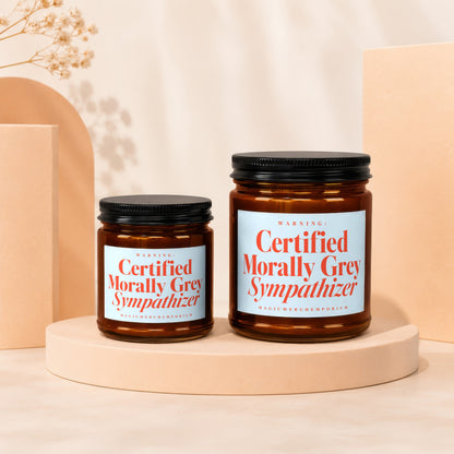 Two amber glass candles with "Certified Morally Grey Sympathizer" labels.
