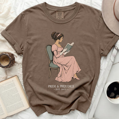 Brown t-shirt with illustration of Jane Austen reading, "Pride & Prejudice Est. 1813"