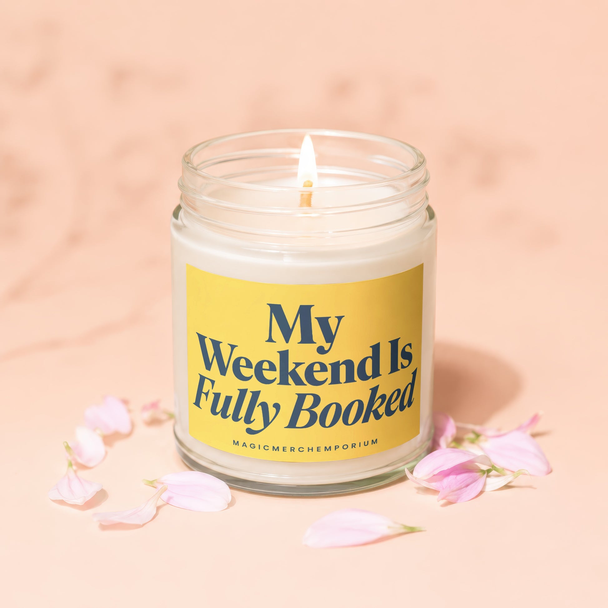 Candle with lit wick and yellow label reading "My Weekend Is Fully Booked"