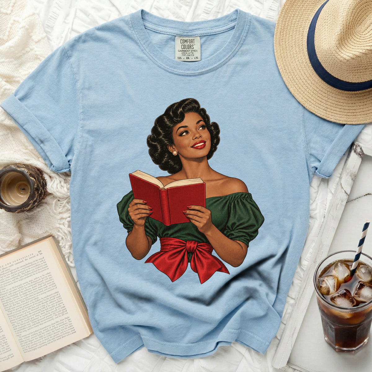 Light blue t-shirt with illustration of a woman reading a red book.