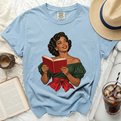 Light blue t-shirt with illustration of a woman reading a red book.