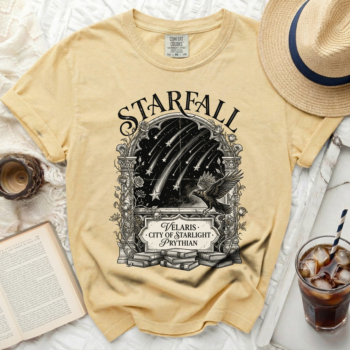 Yellow t-shirt with "Starfall" design featuring a raven, shooting stars, and "Velaris · City of Starlight · Prythian."
