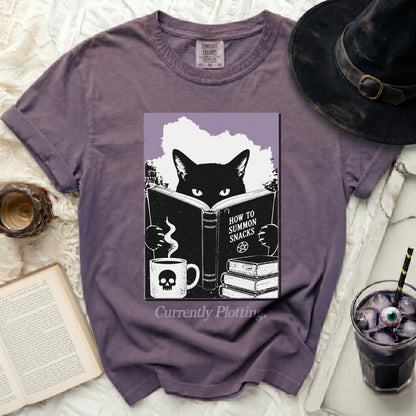 T-shirt with black cat reading "How To Summon Snacks" book, skull mug.