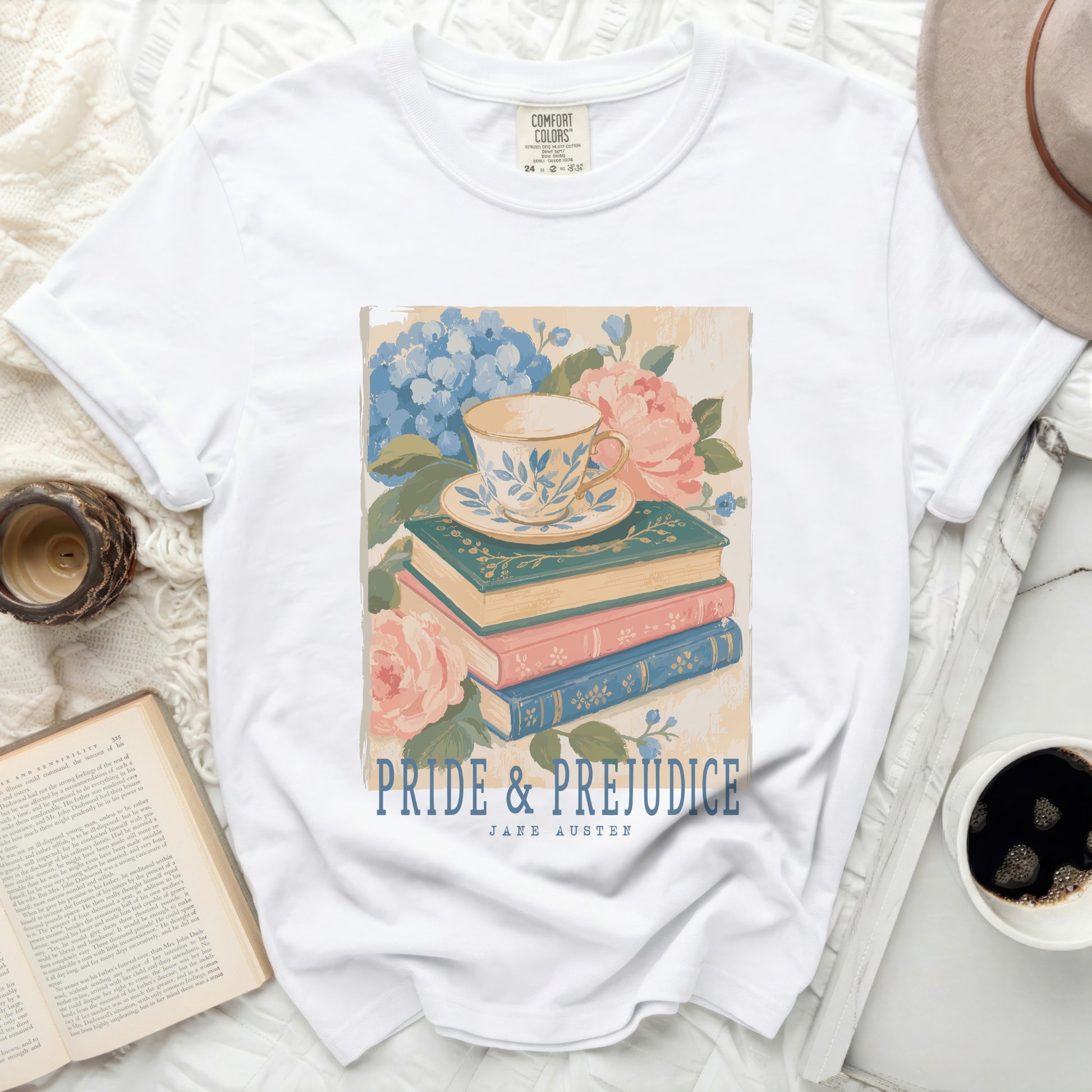 White t-shirt with "Pride & Prejudice" Jane Austen design of teacup and books.