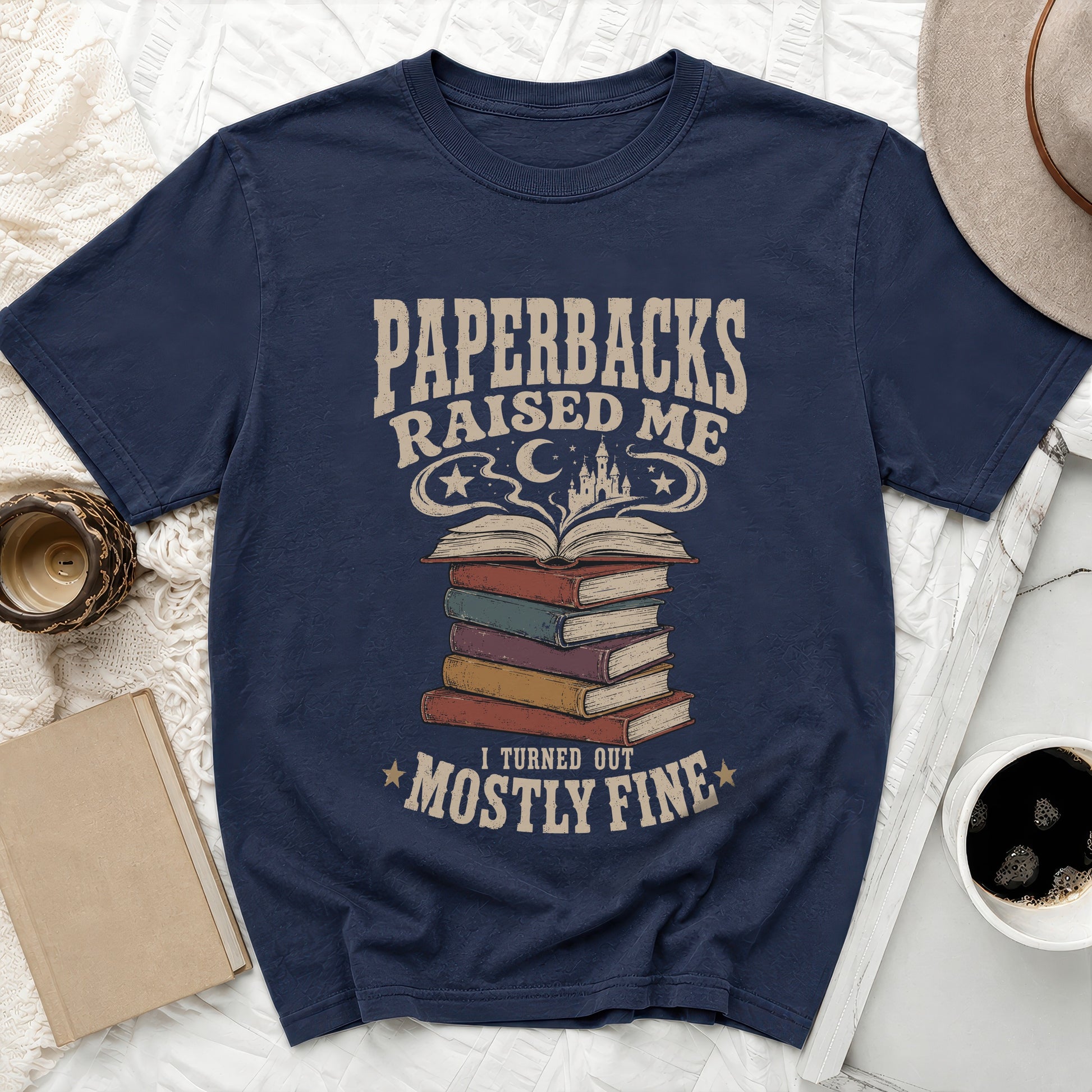 Navy t-shirt with "Paperbacks Raised Me I Turned Out Mostly Fine" text and stacked books graphic.