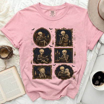 Pink t-shirt with skeletons reading books in decorative frames.