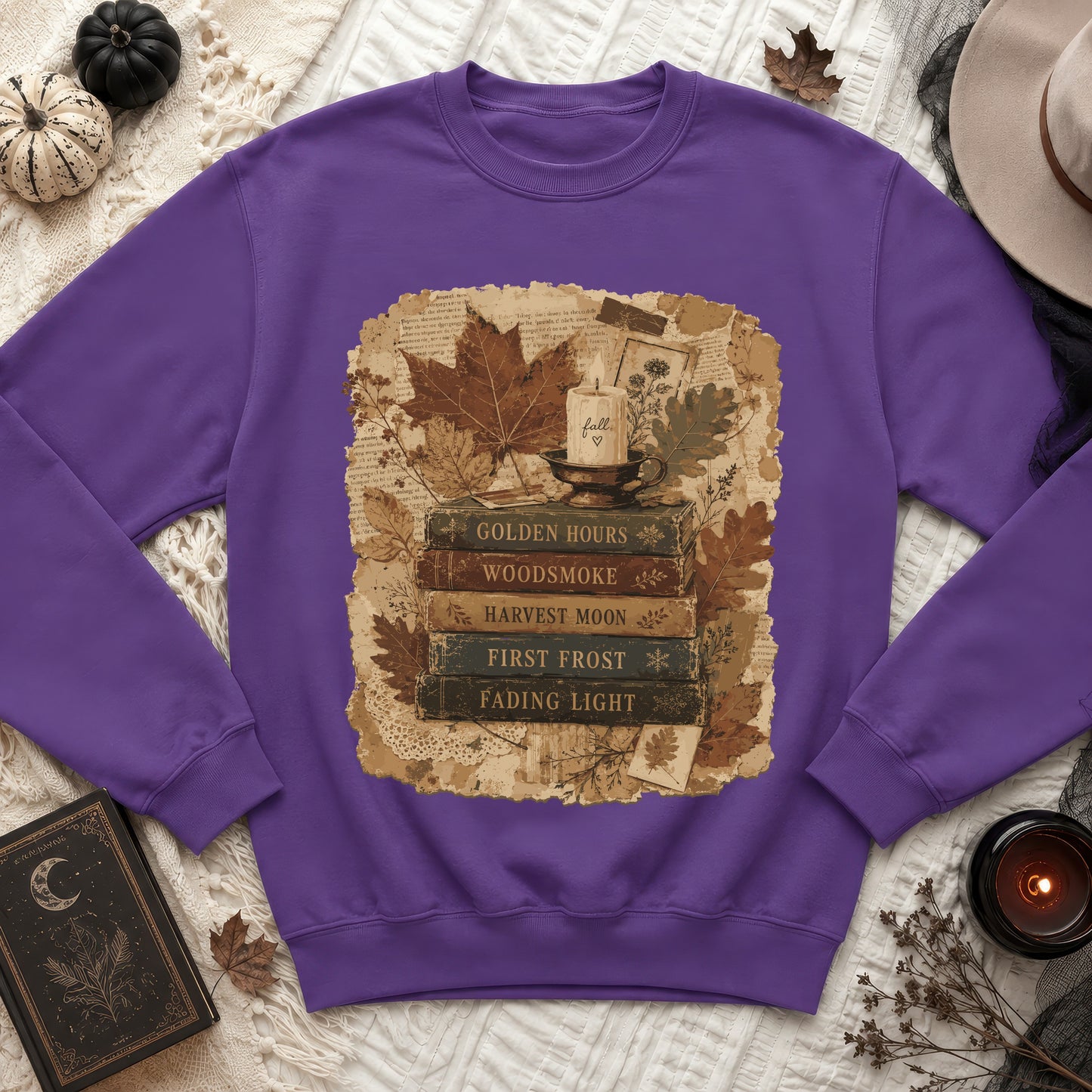 Purple sweatshirt with a vintage autumn graphic featuring books, a candle, and fall leaves.