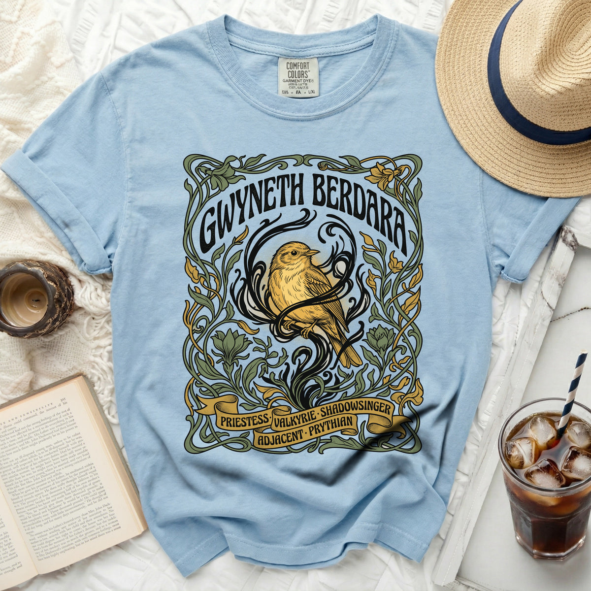 Light blue t-shirt with art nouveau design of bird and text.
