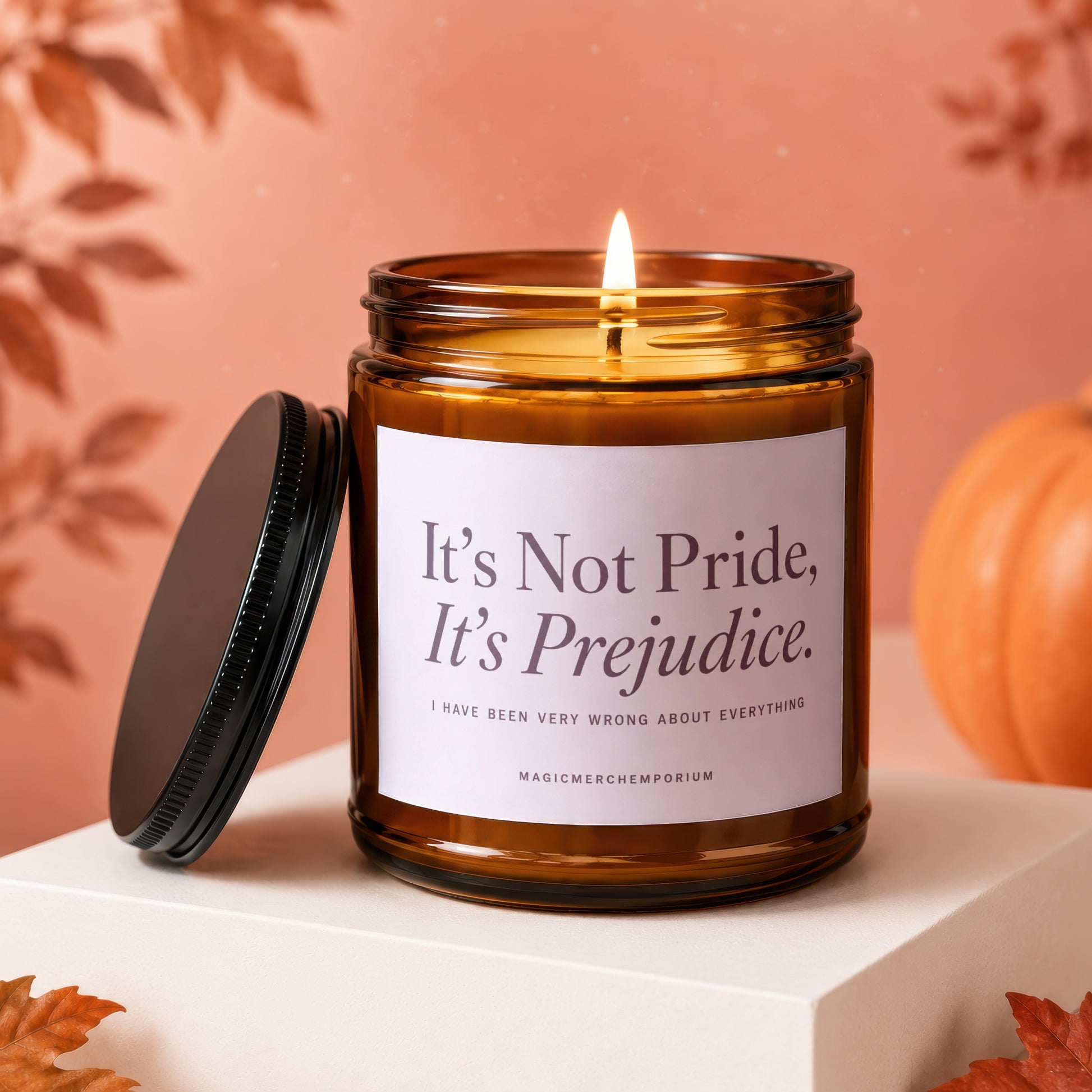 Amber jar candle with lit flame, featuring "It's Not Pride, It's Prejudice." text.