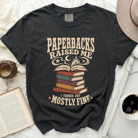 Dark t-shirt with "Paperbacks Raised Me" and books graphic.