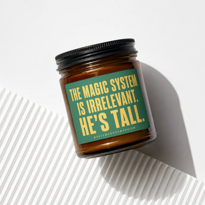 Amber candle with green label quoting "THE MAGIC SYSTEM IS IRRELEVANT. HE'S TALL."