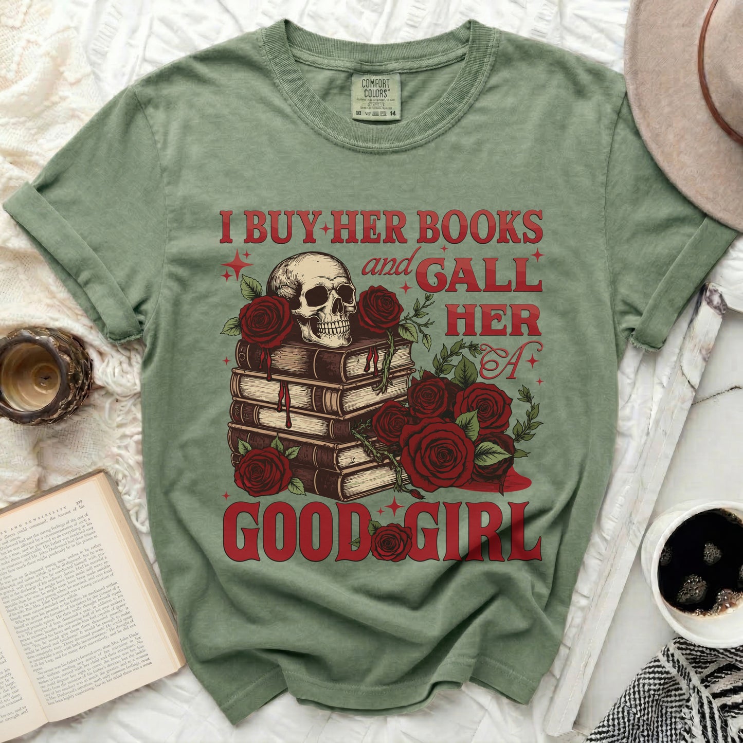 Green t-shirt with skull, books, roses, and text "I BUY HER BOOKS and GALL HER A GOOD GIRL".