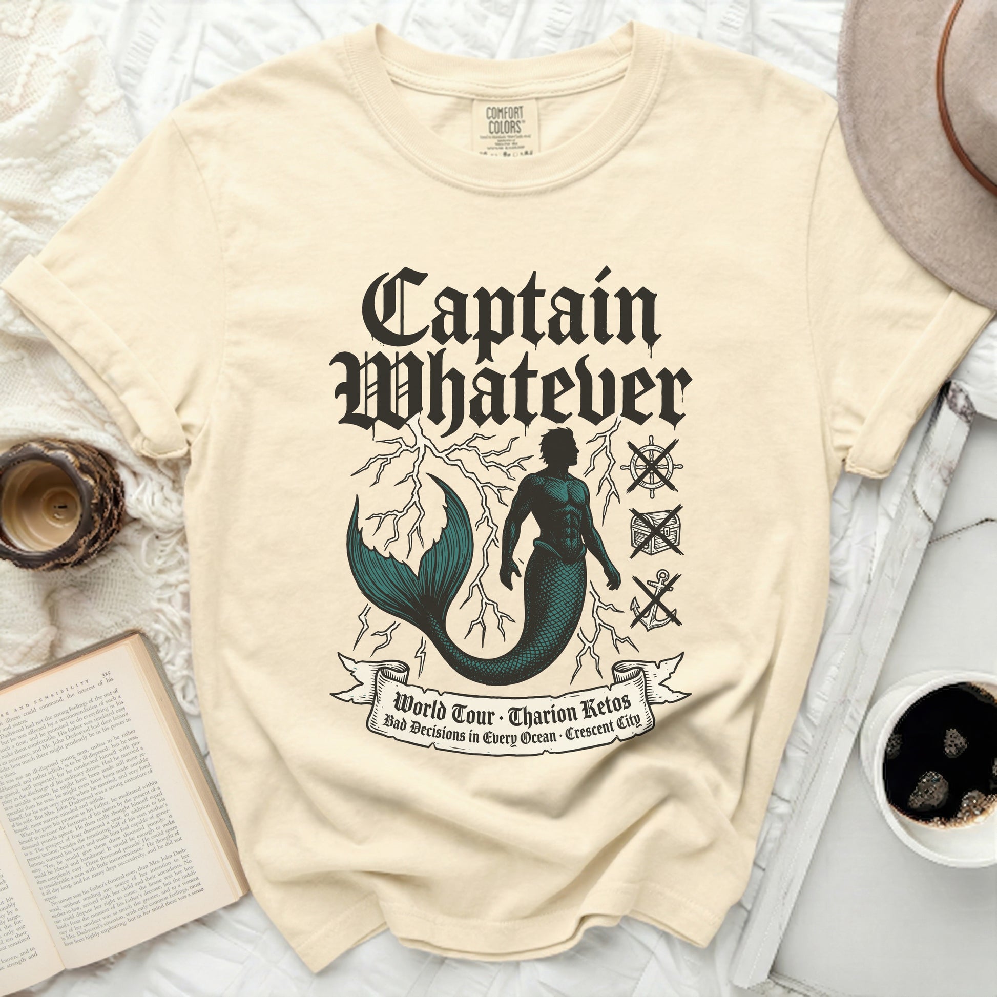 Cream t-shirt with "Captain Whatever" and nautical graphics.