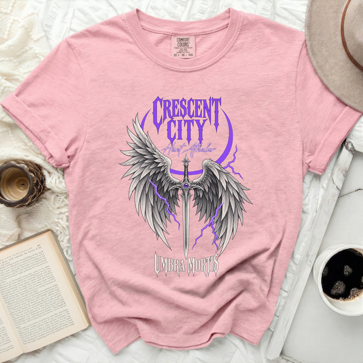 Pink t-shirt with a winged sword graphic and text "Crescent City Hunt Athalor Umbra Mortis".