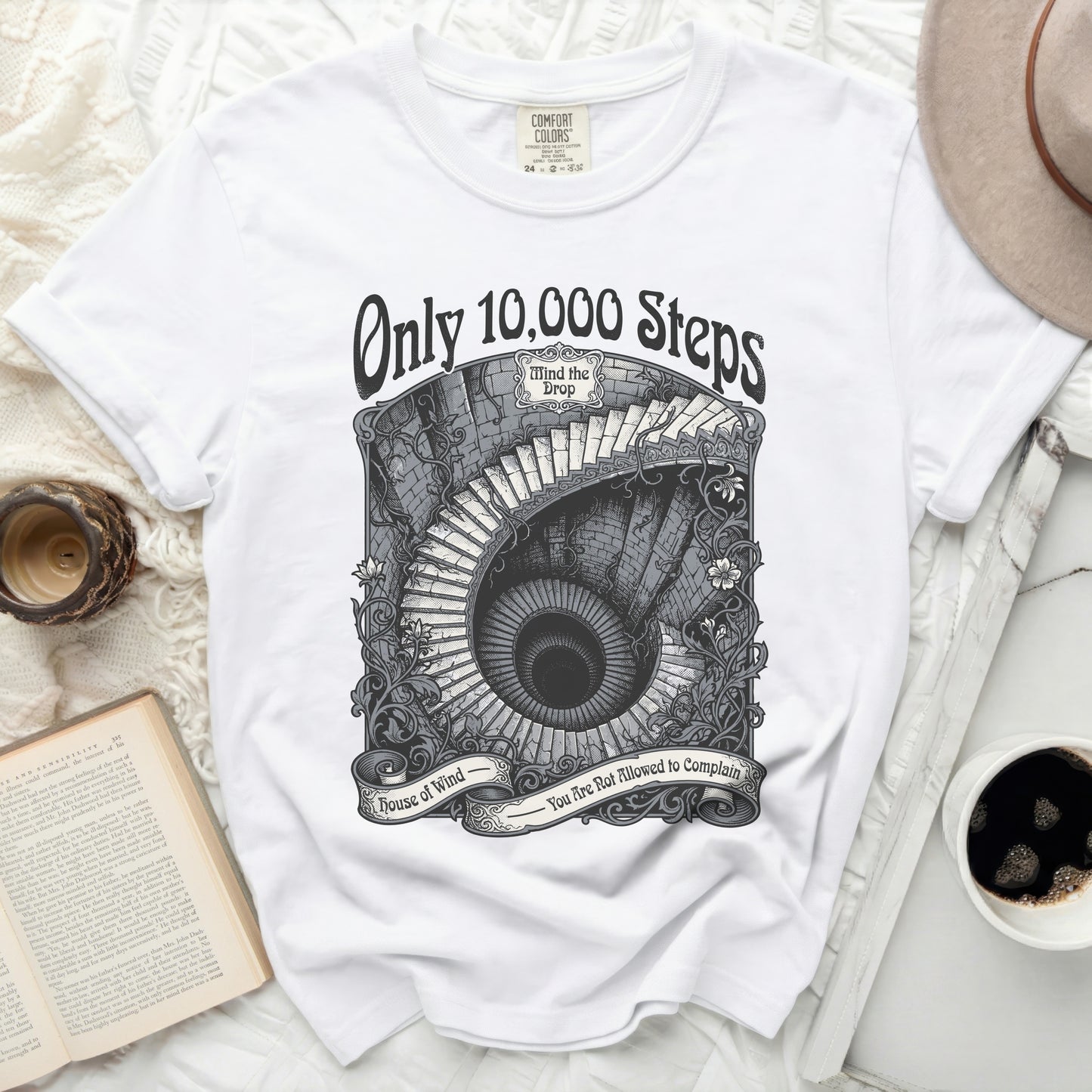 White t-shirt with "Only 10,000 Steps Mind the Drop House of Wind You Are Not Allowed to Complain" graphic.