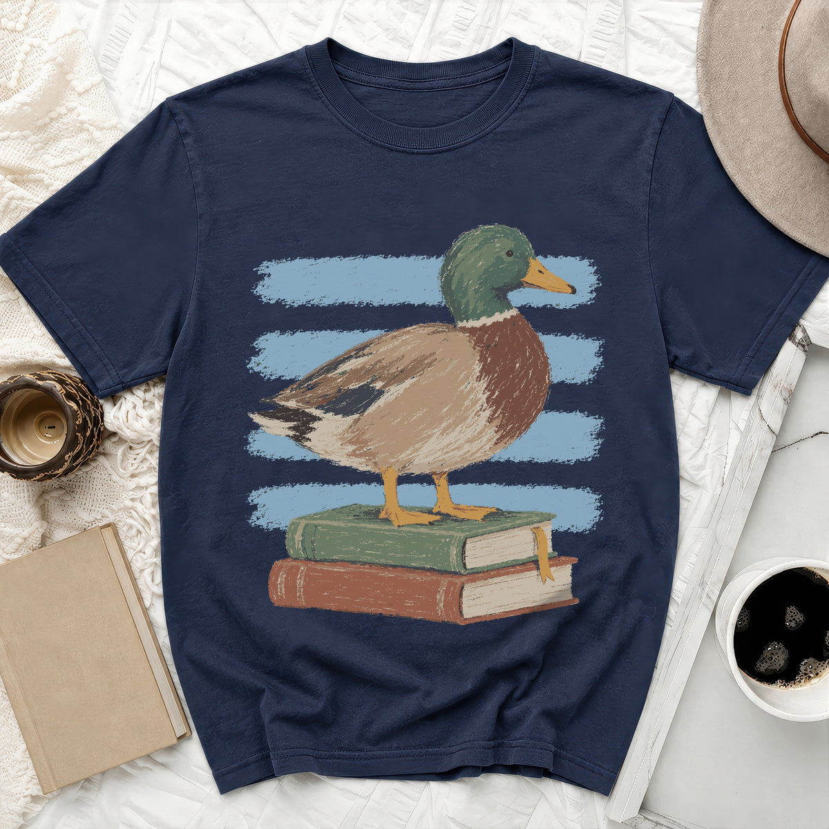 Mallard duck standing on stacked books with blue stripes on dark t-shirt.