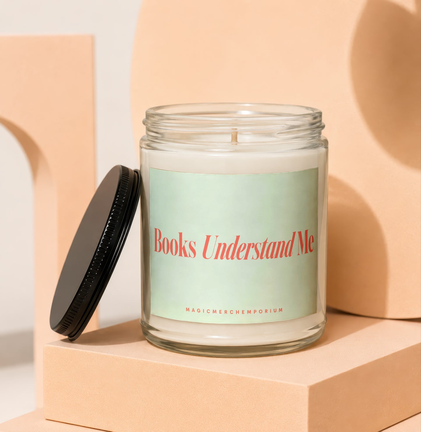 Candle in glass jar with lid off, reading "Books Understand Me."