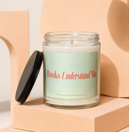 Candle in glass jar with lid off, reading "Books Understand Me."