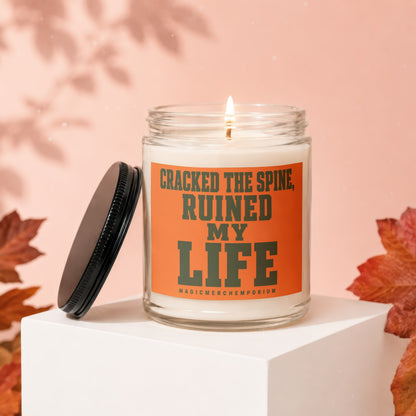 Candle with orange label reading "CRACKED THE SPINE, RUINED MY LIFE".