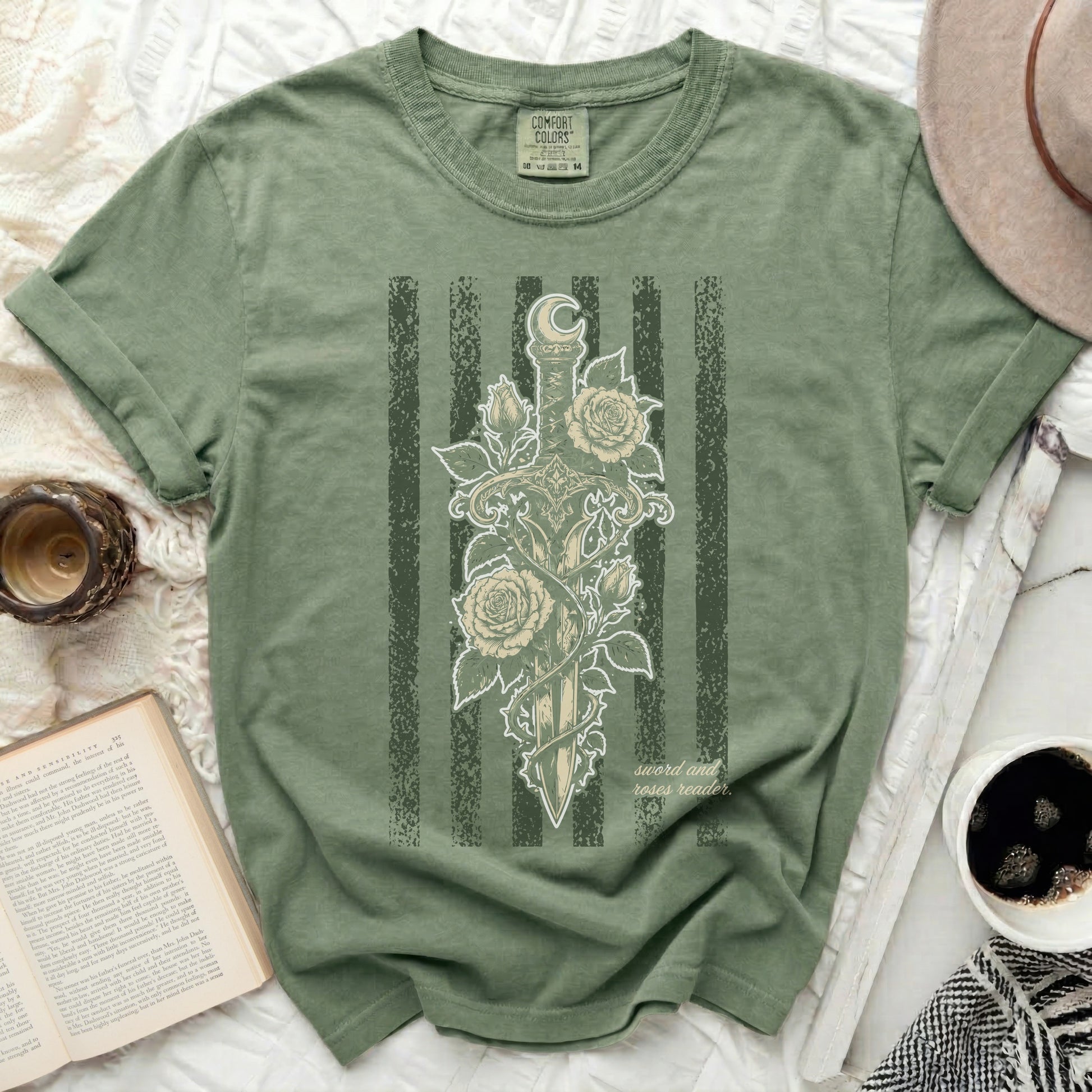 Green t-shirt with sword, roses, moon, and "sword and roses reader" text.