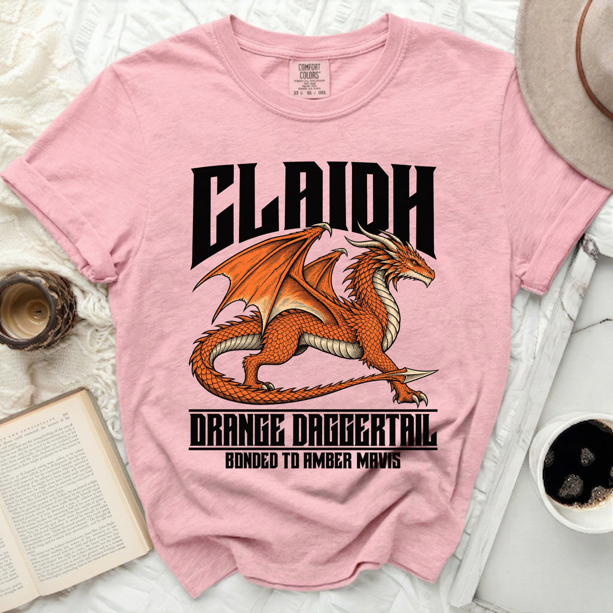 Pink t-shirt with text CLAIIDH, ORANGE DAGGERTAIL, BONDED TO AMBER MAVIS, and orange dragon.
