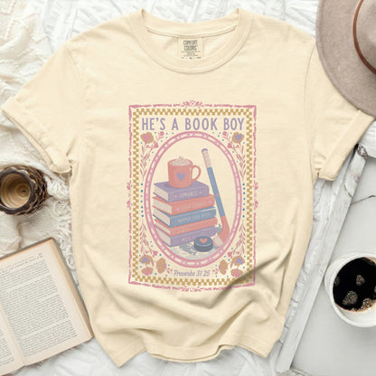 Cream t-shirt with "He's a Book Boy" and stacked books graphic.