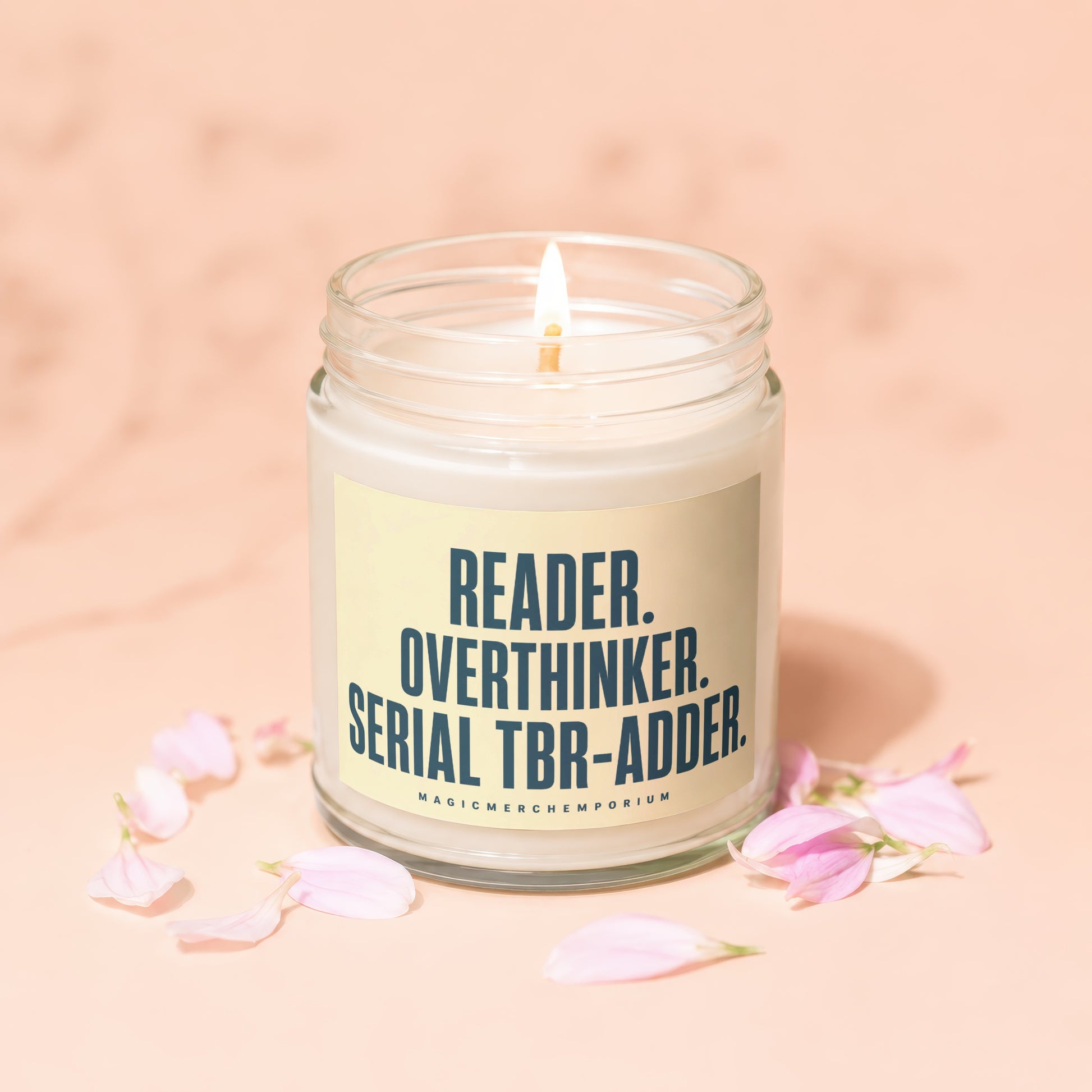 Candle with text "READER. OVERTHINKER. SERIAL TBR-ADDER." and "MAGICMERCH`EMPORIUM".