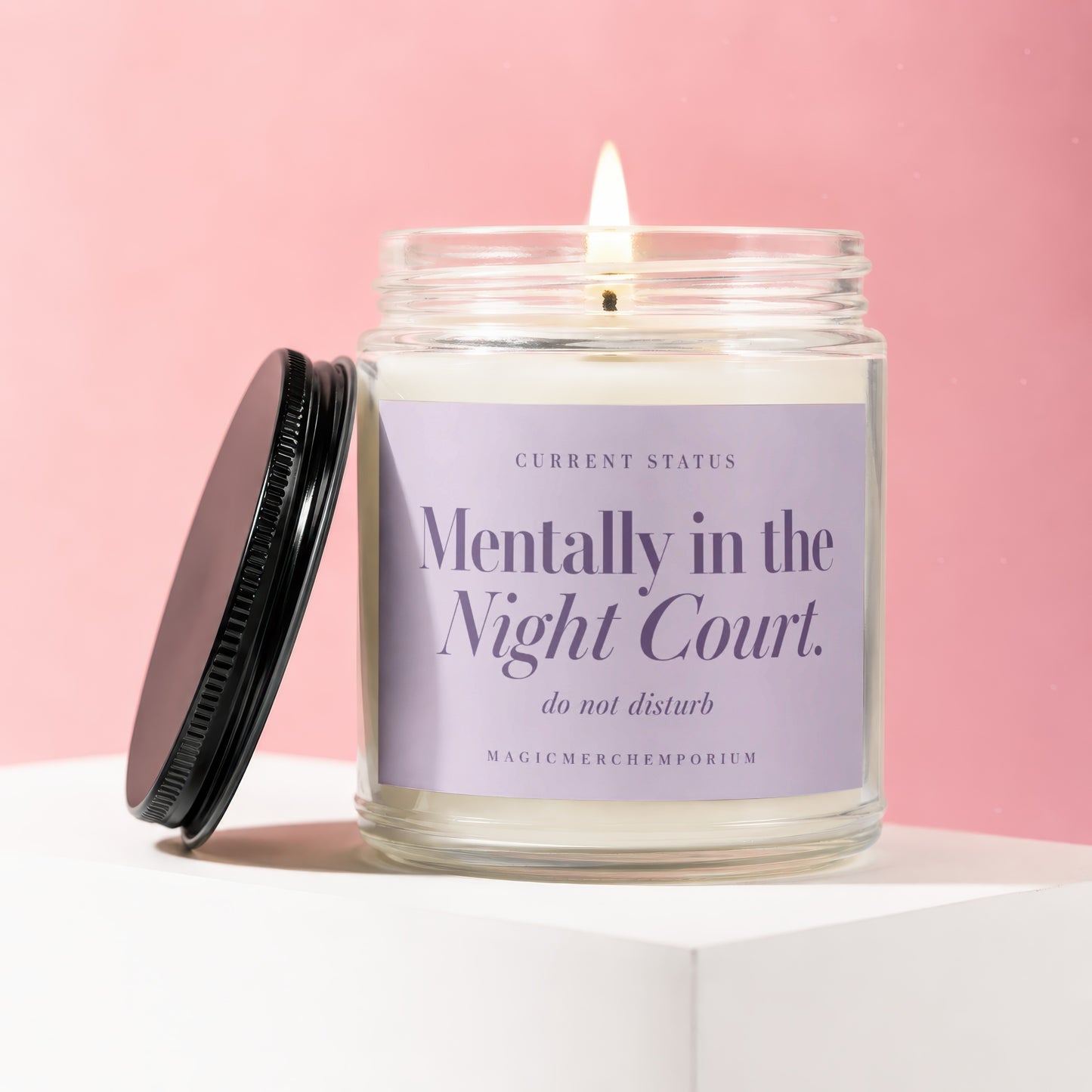 Glass candle with lit wick, "Mentally in the Night Court" text and black lid.