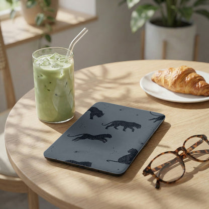 Gray case with black tiger illustrations and stars, next to a glass of green drink.