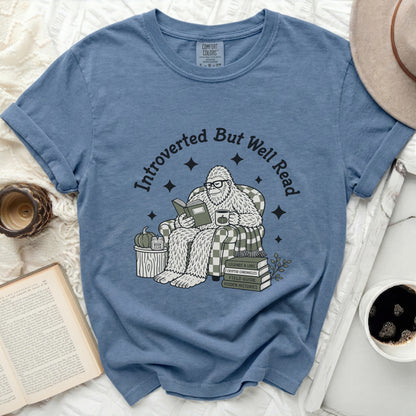 Bigfoot reading a book with the text "Introverted But Well Read"