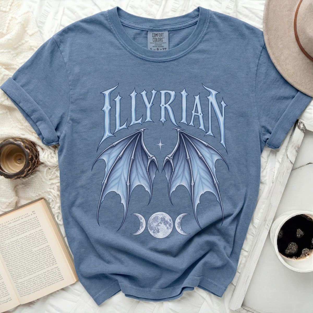 Blue t-shirt with "ILLYRIAN" text, bat wings, and moon phases graphic.