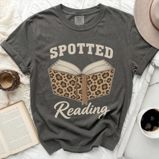 T-shirt with "Spotted Reading" text and leopard print book graphic.