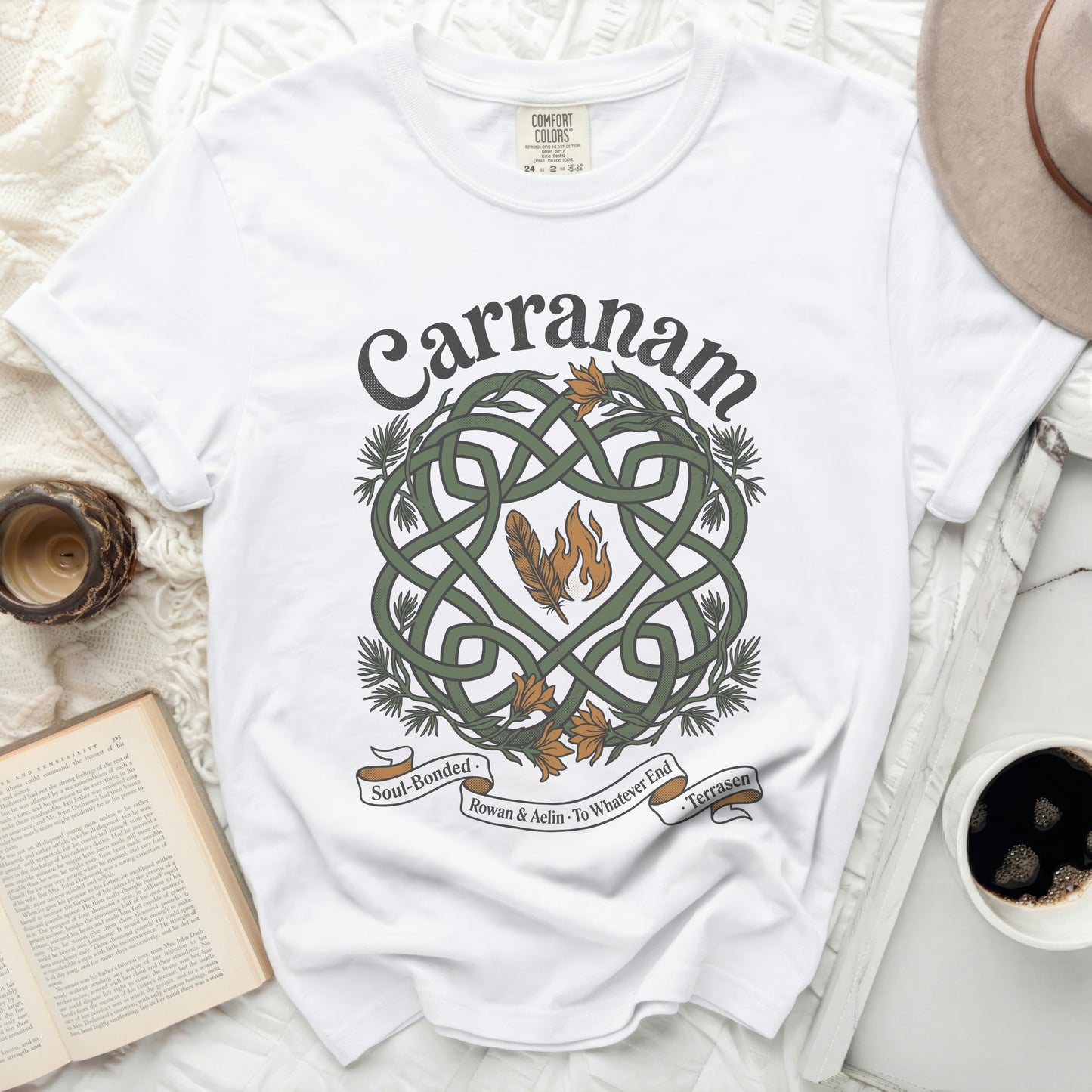 White t-shirt with "Carranam" Celtic knot design, feathers, and text.