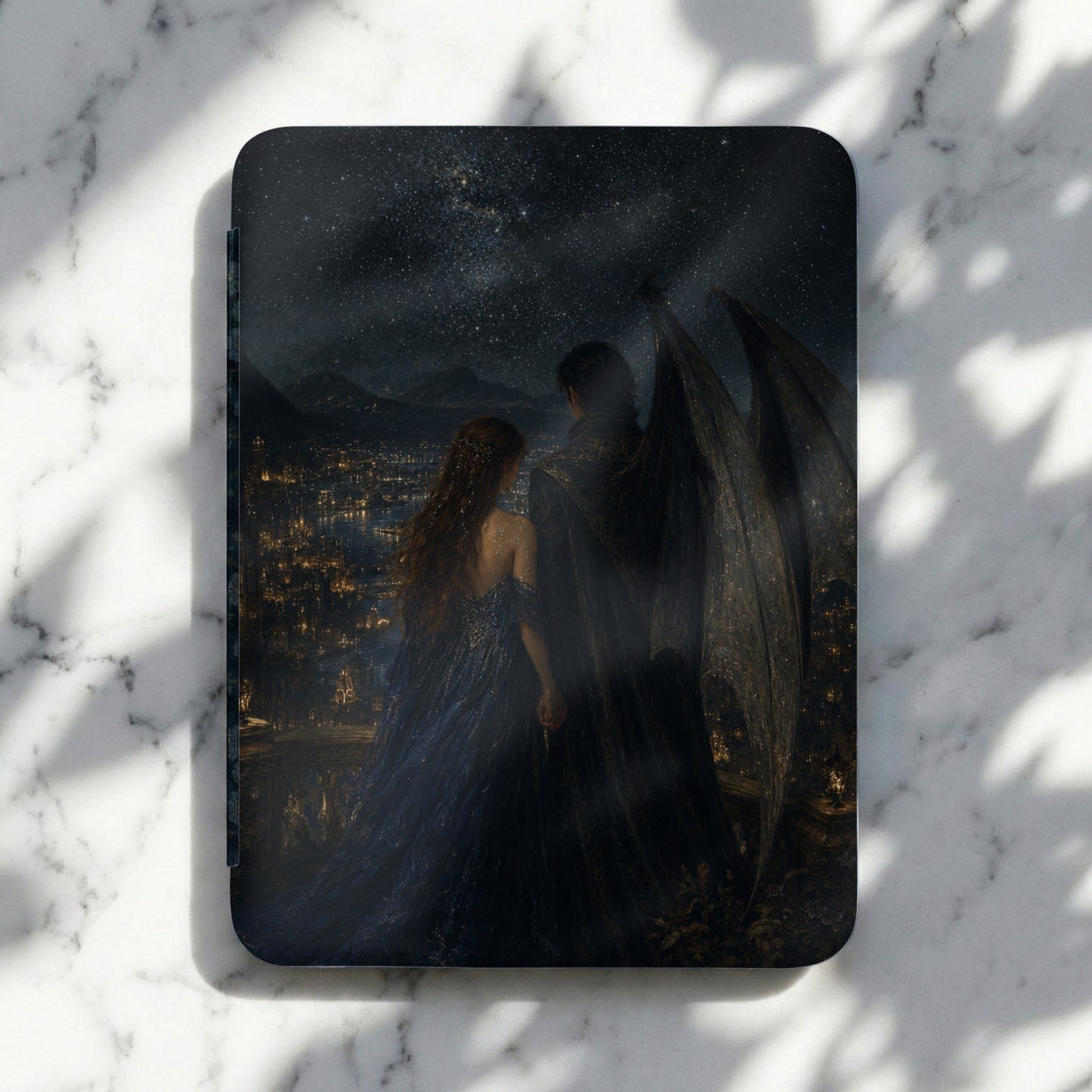 Book cover art shows couple with large wings overlooking a city at night.