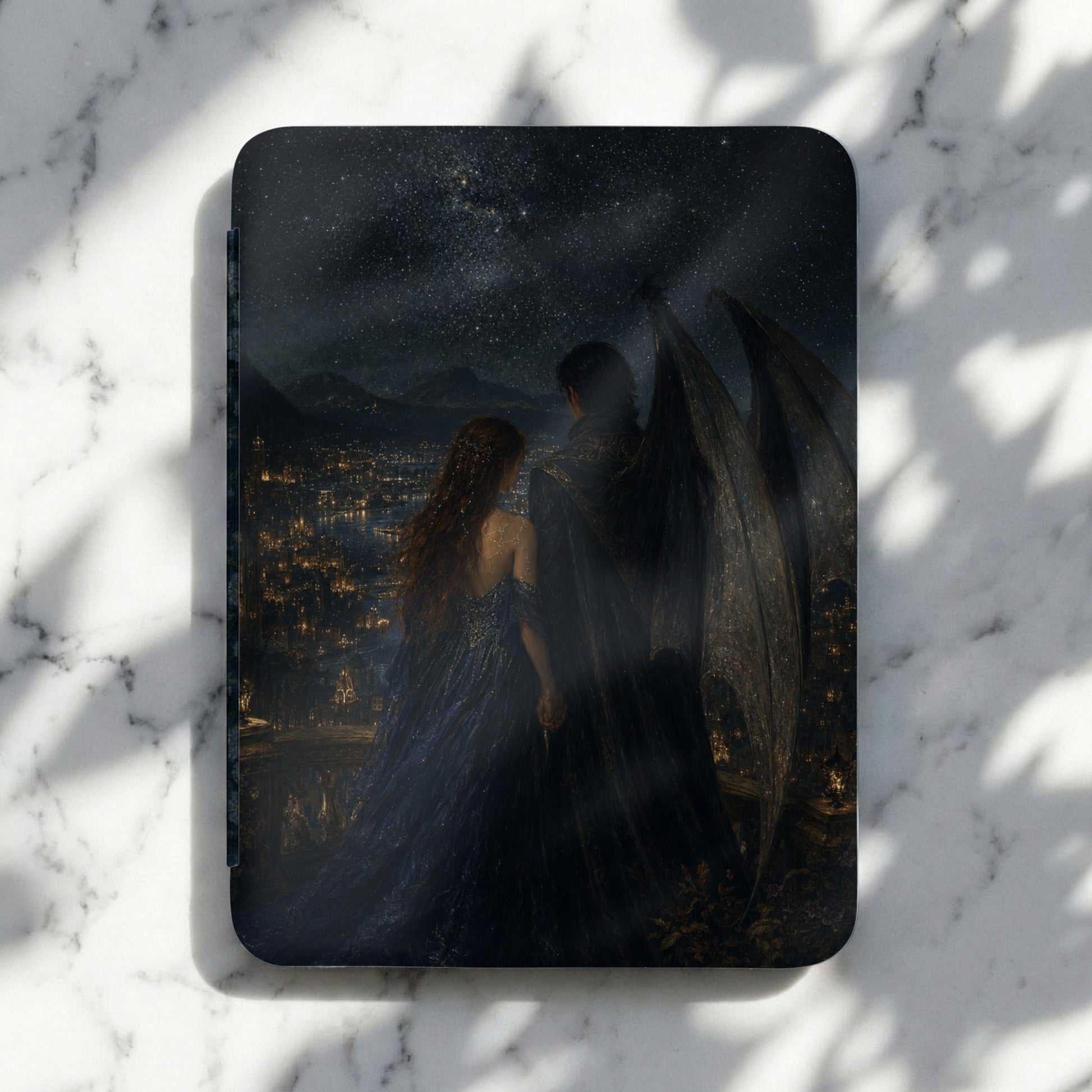 Book cover art shows couple with large wings overlooking a city at night.