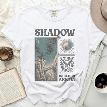 White t-shirt with "Shadow Wielder Aretia" text and graphic art.