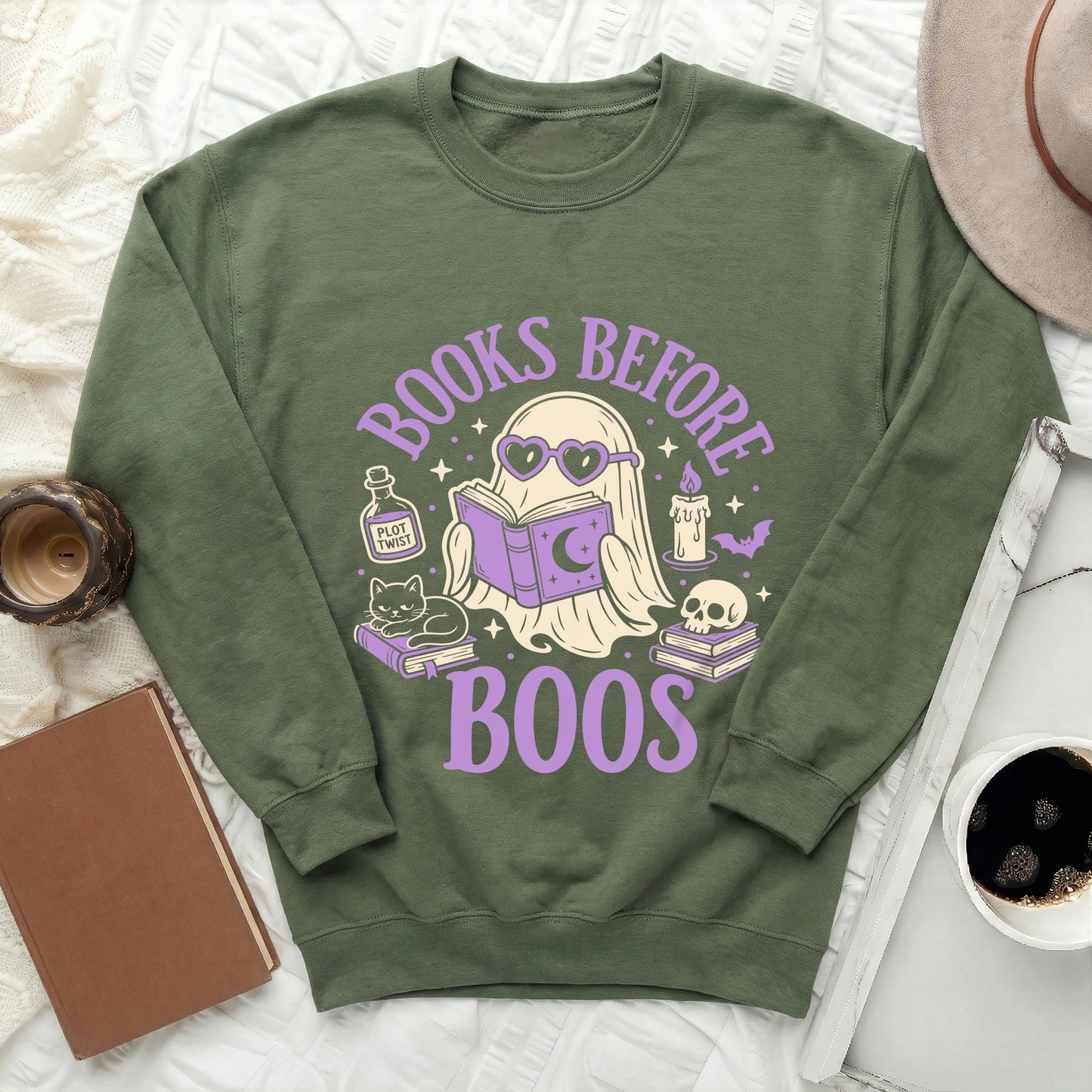 Green sweatshirt with graphic of ghost reading, cat, and skull, says "Books Before Boos".
