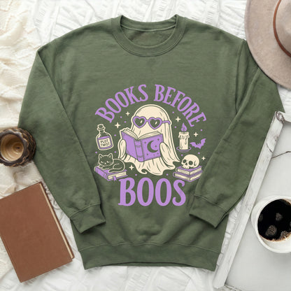 Green sweatshirt with graphic of ghost reading, cat, and skull, says "Books Before Boos".