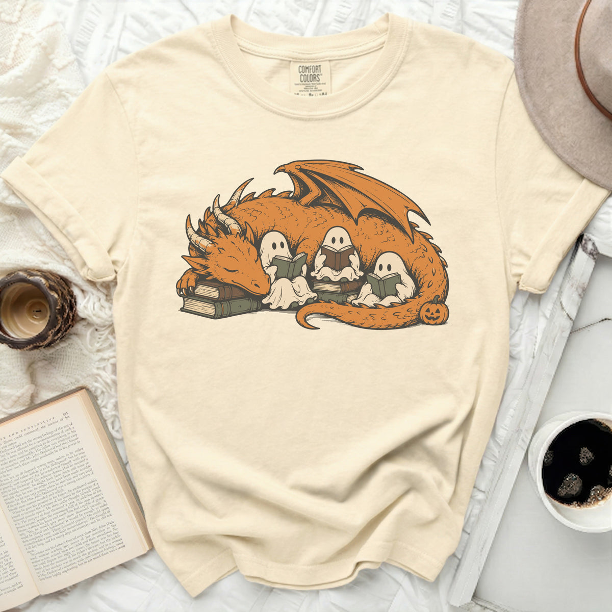 Orange dragon and ghosts reading books on stacked books with a pumpkin.